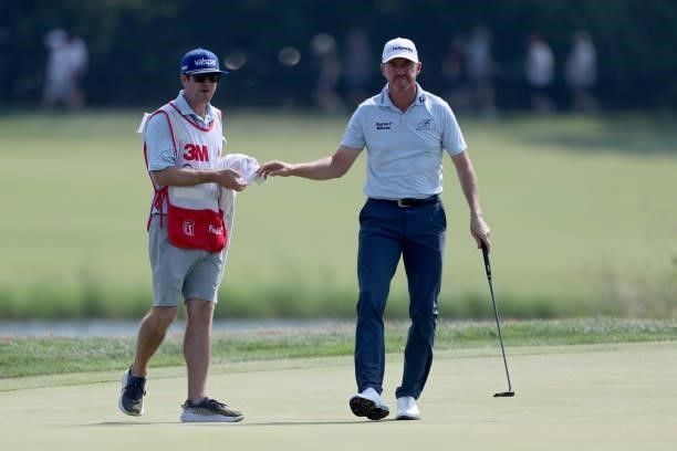 Jimmy Walker hands his ball to his caddie on the 17th green during the Third Round of the 3M Open at TPC Twin Cities on July 24, 2021 in Blaine,...