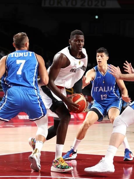 Isaac Bonga of Team Germany drives between Stefano Tonut and Simone Fontecchio of Team Italy during the first half on day two of the Tokyo 2020...