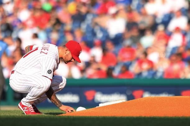 Pitcher Vince Velasquez of the Philadelphia Phillies writes on the dirt behind the mound before his first pitch against the Atlanta Braves during the...