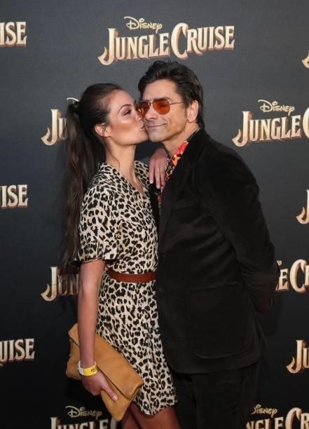 Caitlin McHugh and John Stamos arrive at the world premiere for JUNGLE CRUISE, held at Disneyland in Anaheim, California on July 24, 2021.