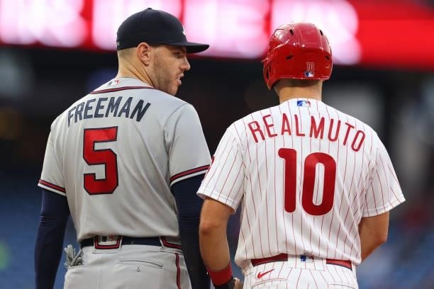 Freddie Freeman of the Atlanta Braves talks with J.T. Realmuto of the Philadelphia Phillies during a game at Citizens Bank Park on July 24, 2021 in...