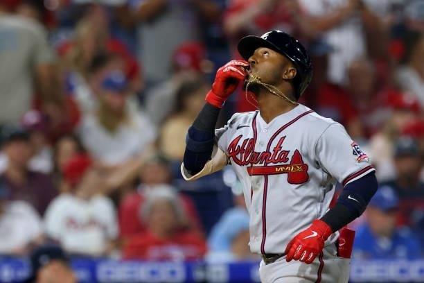 Ozzie Albies of the Atlanta Braves kisses his crucifix after he hit a three-run home run during the eighth inning against the Philadelphia Phillies...
