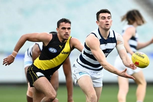 Mark O'Connor of the Cats handballs during the round 19 AFL match between Geelong Cats and Richmond Tigers at Melbourne Cricket Ground on July 25,...