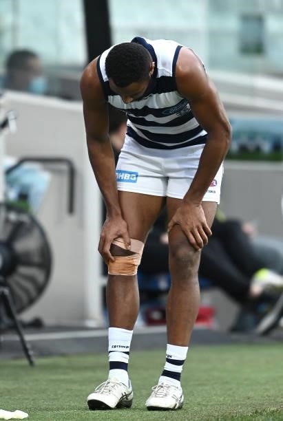 Esava Ratugolea of the Cats grabs at his knee as he comes to the bench during the round 19 AFL match between Geelong Cats and Richmond Tigers at...