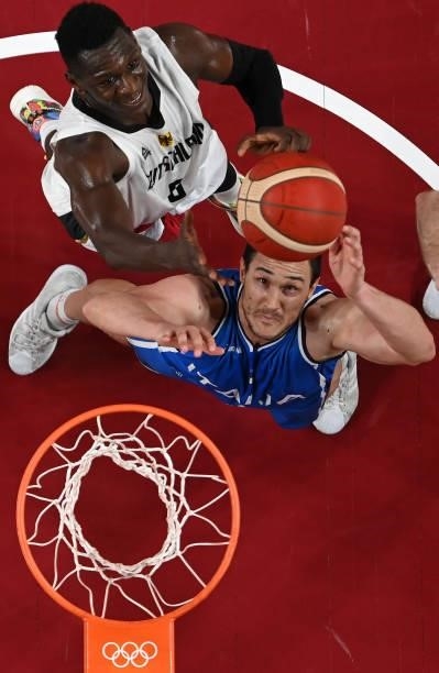 Danilo Gallinari of Team Italy and Isaac Bonga of Team Germany eye the ball for a rebound during the second half on day two of the Tokyo 2020 Olympic...