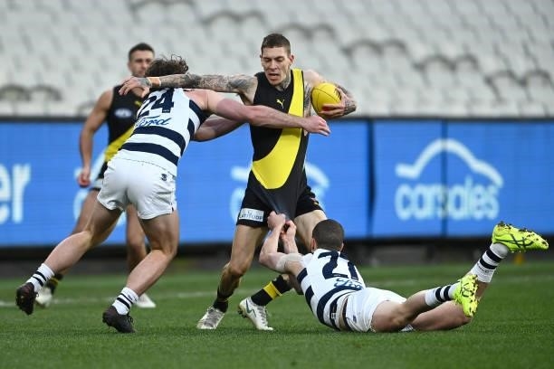 Matthew Parker of the Tigers is tackled by Sam Menegola and Jed Bews of the Cats during the round 19 AFL match between Geelong Cats and Richmond...