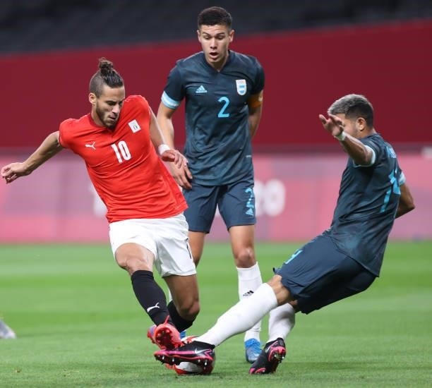 Ramadan Sobhi of Team Egypt battles for possession with Facundo Medina of Team Argentina during the Men's First Round Group C match between Egypt and...