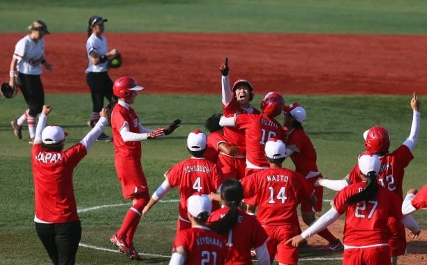 Eri Yamada of Team Japan celebrates her game-winning RBI in the eighth inning with teammates as Kelsey Harshman and Janet Leung of Team Canada look...