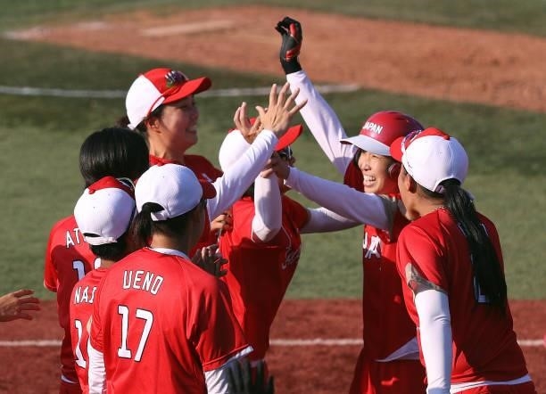 Eri Yamada of Team Japan celebrates her game-winning RBI in the eighth inning against Team Canada with teammates during the Softball Opening Round on...