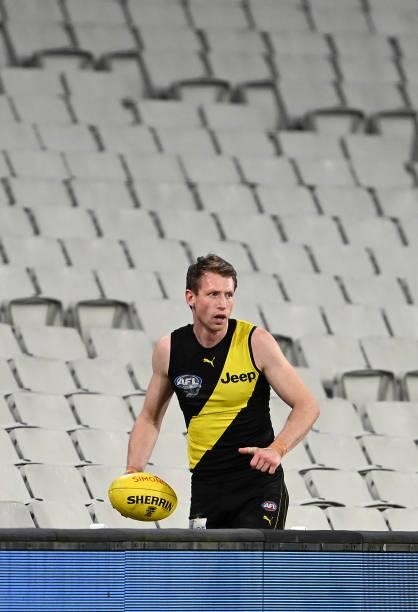Dylan Grimes of the Tigers retrieves the ball from the grandstand during the round 19 AFL match between Geelong Cats and Richmond Tigers at Melbourne...