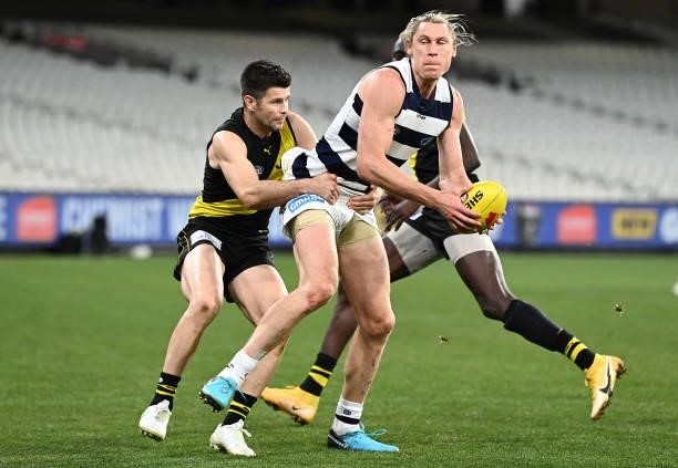 Mark Blicavs of the Cats is tackled by Trent Cotchin of the Tigers during the round 19 AFL match between Geelong Cats and Richmond Tigers at...