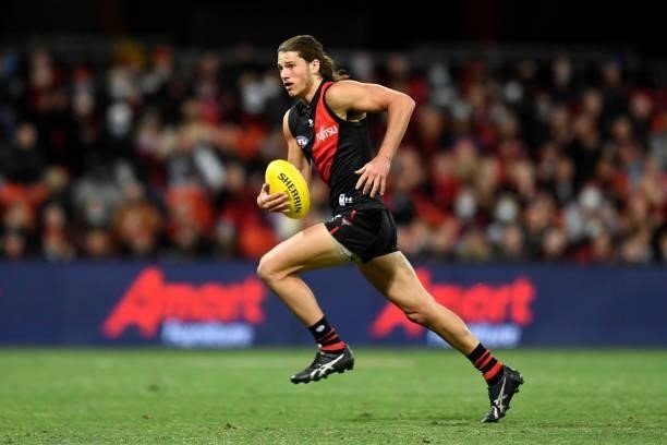 Archie Perkins of the Bombers runs with the ball before kicking a goal during the round 19 AFL match between Essendon Bombers and Greater Western...