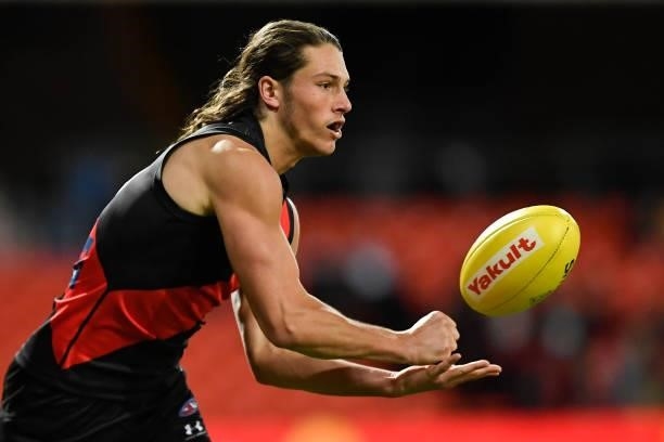 Archie Perkins of the Bombers handballs during the round 19 AFL match between Essendon Bombers and Greater Western Sydney Giants at Metricon Stadium...