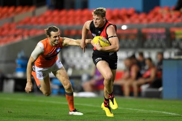 Jake Stringer of the Bombers fends off the tackle from Phil Davis of the Giants during the round 19 AFL match between Essendon Bombers and Greater...