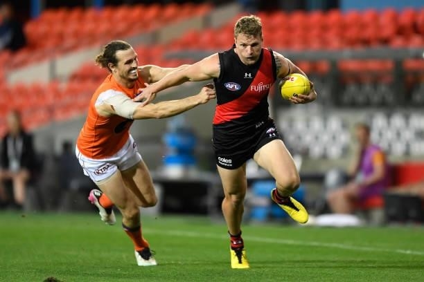 Jake Stringer of the Bombers fends off the tackle from Phil Davis of the Giants during the round 19 AFL match between Essendon Bombers and Greater...