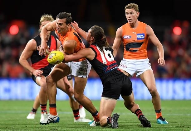 Isaac Cumming of the Giants is tackled during the round 19 AFL match between Essendon Bombers and Greater Western Sydney Giants at Metricon Stadium...