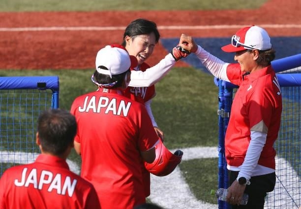 Eri Yamada of Team Japan celebrates with head coach Reika Utsugi after Yamada's game-winning RBI in the eighth inning against Team Canada with...