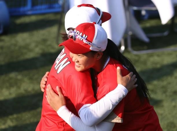 Miu Goto of Team Japan hugs head coach Reika Utsugi after their 1-0 win against Team Canada during the Softball Opening Round on day two of the Tokyo...