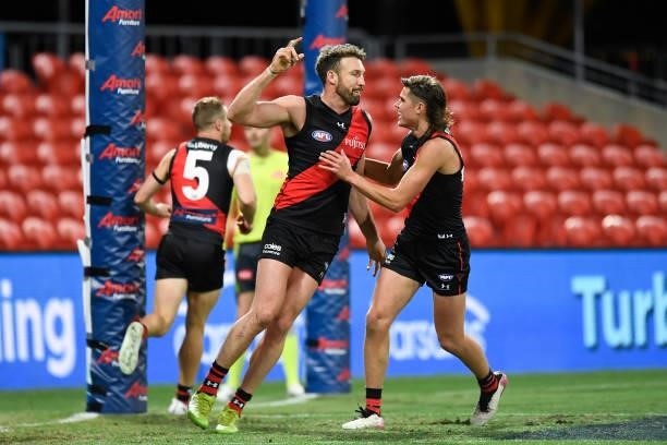 Cale Hooker of the Bombers celebrates with team mates after kicking a goal during the round 19 AFL match between Essendon Bombers and Greater Western...