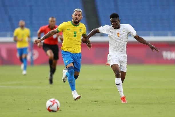Luiz Douglas of Team Brazil battles for possession with Kouadio-Yves Dabila of Team Ivory Coast during the Men's First Round Group D match between...