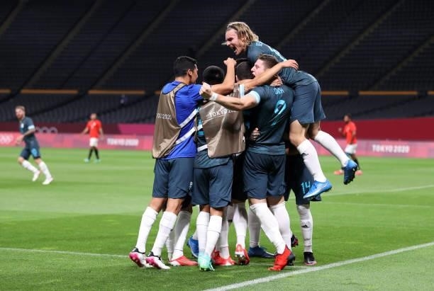 Facundo Medina of Team Argentina celebrates with Pedro de la Vega and teammates after scoring their side's first goal during the Men's First Round...