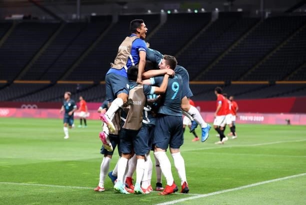 Facundo Medina of Team Argentina celebrates with teammates after scoring their side's first goal during the Men's First Round Group C match between...