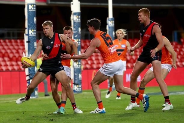 Jake Stringer of Essendon is tackled during the round 19 AFL match between Essendon Bombers and Greater Western Sydney Giants at Metricon Stadium on...