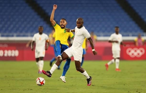Matheus Cunha of Team Brazil battles for possession with Kouadio-Yves Dabila of Team Ivory Coast during the Men's First Round Group D match between...