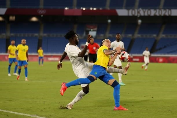 Luiz Douglas of Team Brazil battles for possession with Christian Kouame of Team Ivory Coast during the Men's First Round Group D match between...