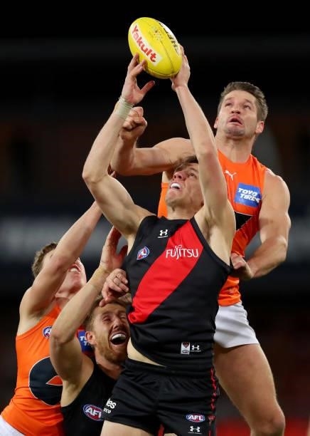 Jordan Ridley of Essendon marks the ball under pressure from Jesse Hogan of the GWS Giants during the round 19 AFL match between Essendon Bombers and...