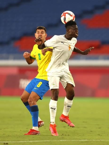 Youssouf Dao of Team Ivory Coast competes for a header with Bruno Guimaraes of Team Brazil during the Men's First Round Group D match between Brazil...