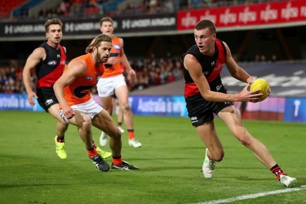 Nik Cox of Essendon runs with the ball during the round 19 AFL match between Essendon Bombers and Greater Western Sydney Giants at Metricon Stadium...
