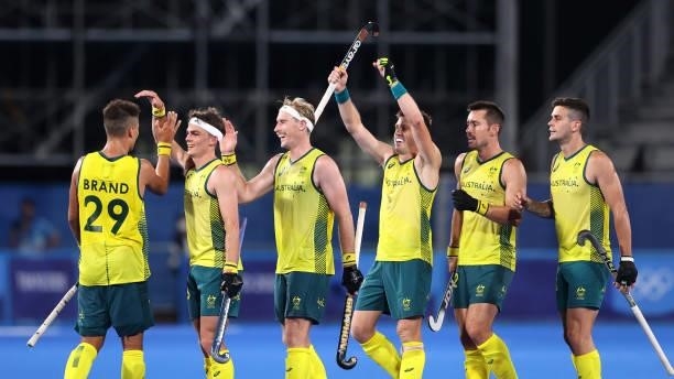 Tim Brand of Team Australia celebrates with team mates after scoring their team's seventh goal during the Men's Preliminary Pool A match between...
