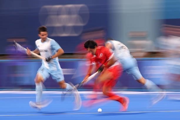 Kenji Kitazato of Team Japan runs with the ball whilst under pressure from Ezequiel Habif Thomas of Team Argentina during the Men's Preliminary Pool...