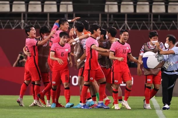 Seungwon Jeong, Dongjun Lee and teammates of Team South Korea celebrates after their side's first goal, an own goal scored by Marius Marin of Team...