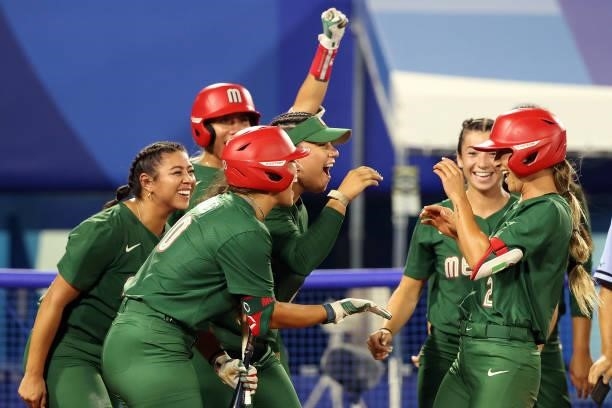 Sydney Romero of Team Mexico is congratulated by teammates at home plate after hitting a home run in the third inning against Team Italy during the...