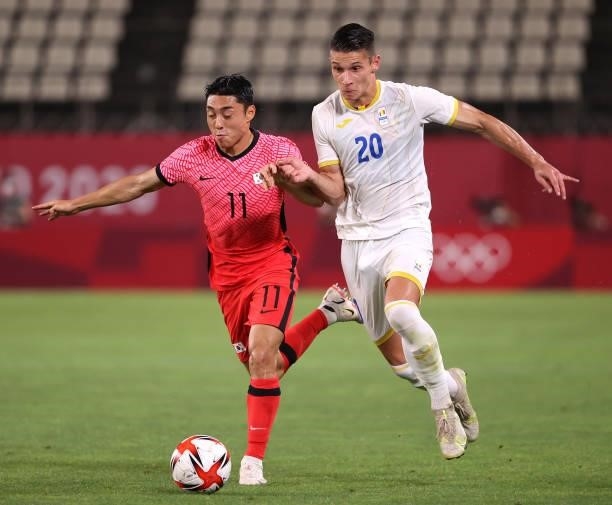 Dongjun Lee of Team South Korea runs with the ball whilst under pressure from Alexandru Dobre of Team Romania during the Men's First Round Group B...