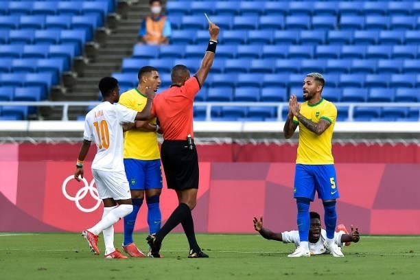 Referee Ismail Elfath of USA shows a yellow card to Douglas Luiz of Brazil during the Tokyo 2020 Olympic Mens Football Tournament match between...