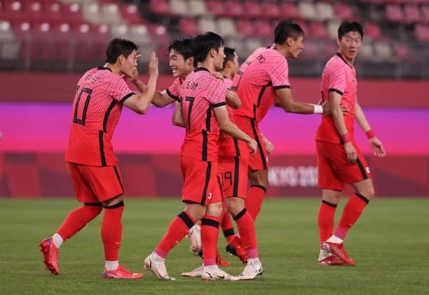 Donggyeong Lee of Team South Korea celebrates with Yoonseong Kang and teammates after scoring their side's second goal during the Men's Group match...