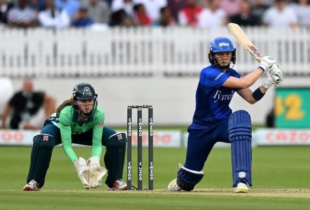 Heather Knight of London Spirit Women plays a shot as Oval Invincibles wicket keeper Sarah Bryce looks on during The Hundred match between London...