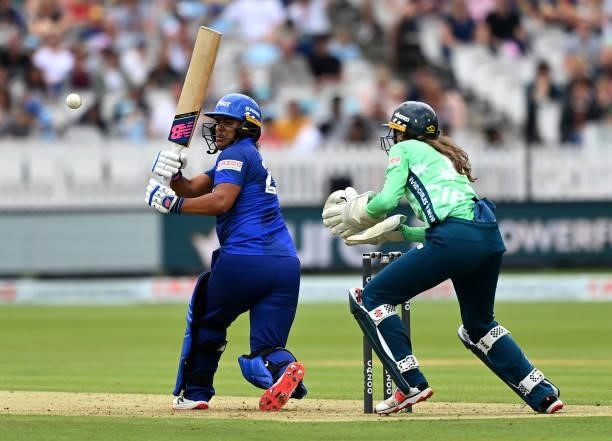 Naomi Dattani of London Spirit Women plays a shot as Oval Invincibles wicket keeper Sarah Bryce looks on during The Hundred match between London...
