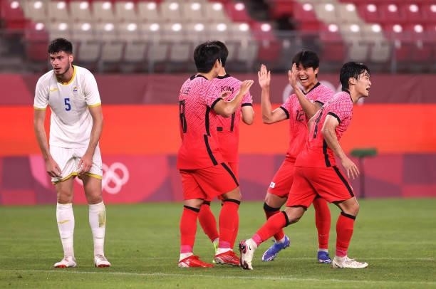 Youngwoo Seol of Team South Korea congratulates teammate Kangin Lee after he scored their side's fourth goal during the Men's First Round Group B...
