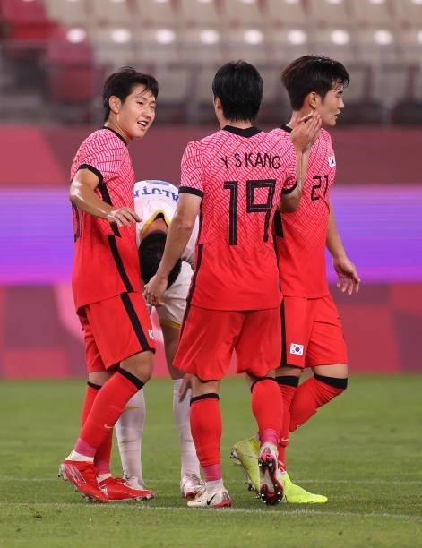 Kangin Lee of Team South Korea celebrates with teammates Yoonseong Kang and Jingyu Kim after scoring their side's fourth goal during the Men's First...