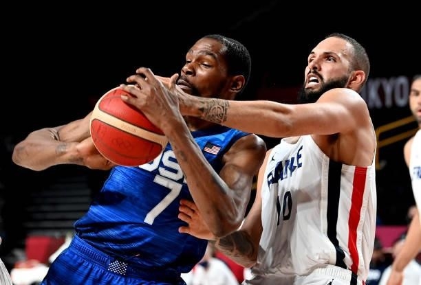 Kevin Durant of the USA is pressured by the defence of Evan Fournier of France during the preliminary rounds of the Men's Basketball match between...