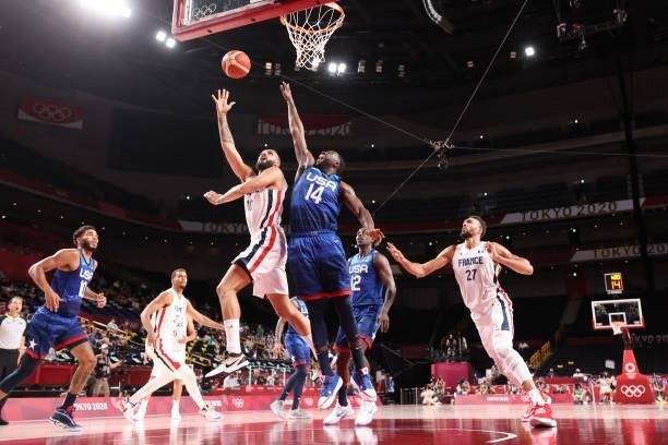 Evan Fournier of Team France drives to the basket for a shot over Draymond Green of Team United States during the second half of the Men's...