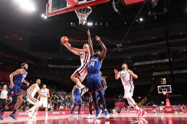 Evan Fournier of Team France drives to the basket for a shot over Draymond Green of Team United States during the second half of the Men's...