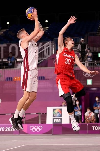 Karlis Lasmanis of Team Latvia shoots under pressure from Keisei Tominaga of Team Japan during the Men's Pool Round match between Latvia and Japan on...
