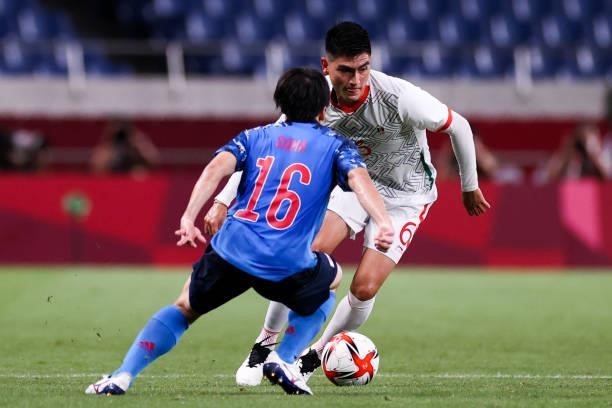 Hayashi Daichi of Japan competes for the ball with Lorona Vladimir of Mexico during the Men's First Round Group A match between Japan and Mexico on...
