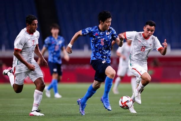Endo Wataru of Japan controls the ball with Montes Cesar of Mexico during the Men's First Round Group A match between Japan and Mexico on day two of...