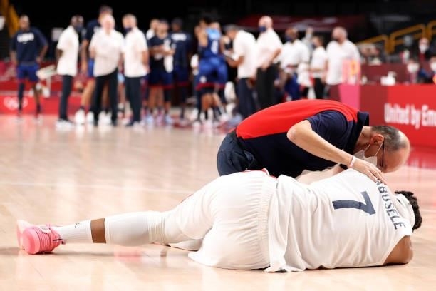 Trainer tends to Guerschon Yabusele of Team France during after he was injured in the game against the United States of American in Men's Preliminary...